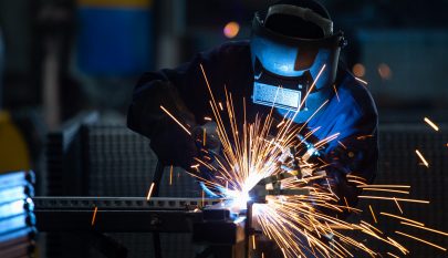 Workers wearing industrial uniforms and Welded Iron Mask at Steel welding plants, industrial safety first concept.